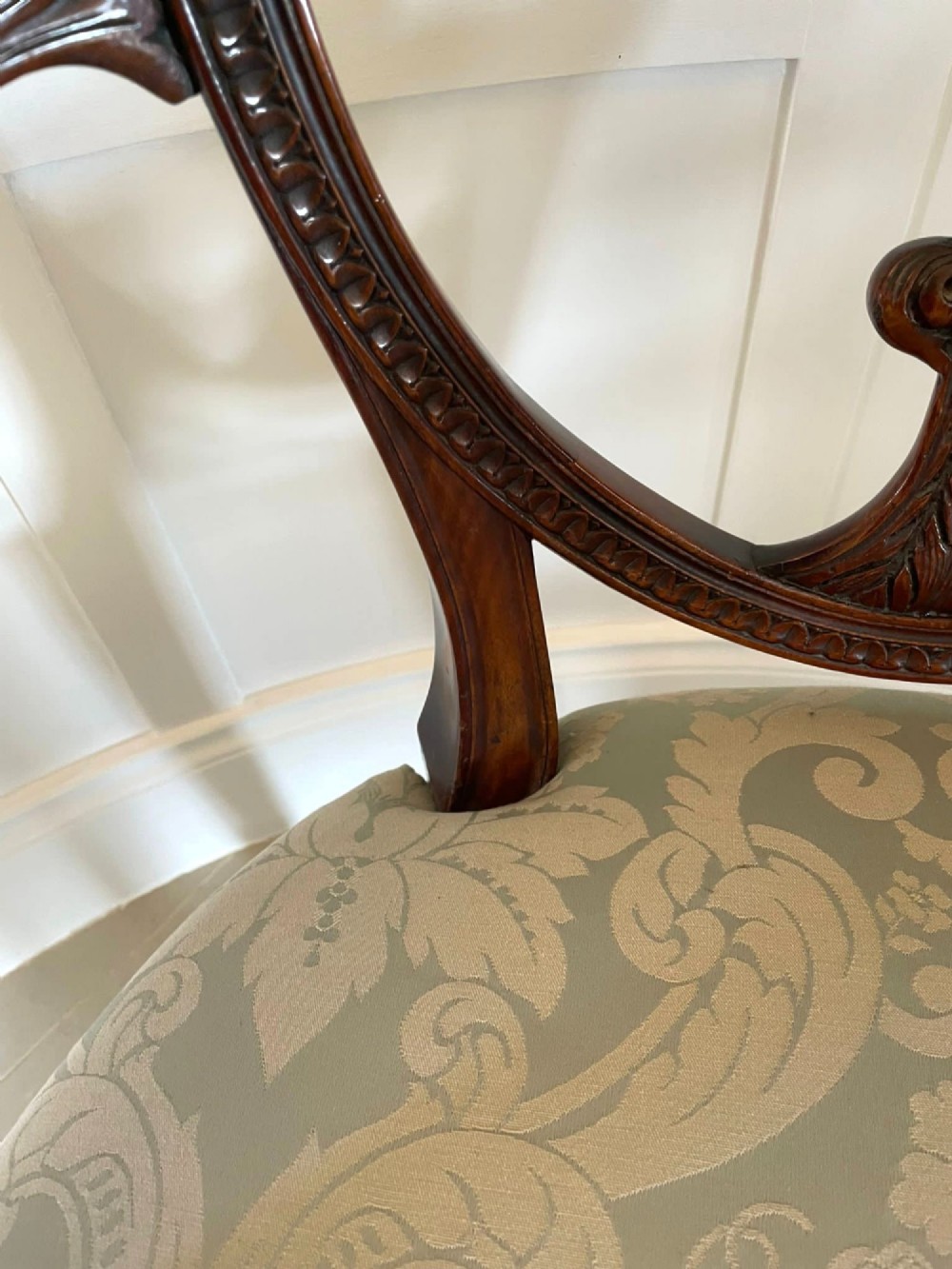 A pair of carved mahogany open armchairs featuring oval backs with carved splats, padded armrests, and pale green patterned fabric seats on fluted front legs. View XIII