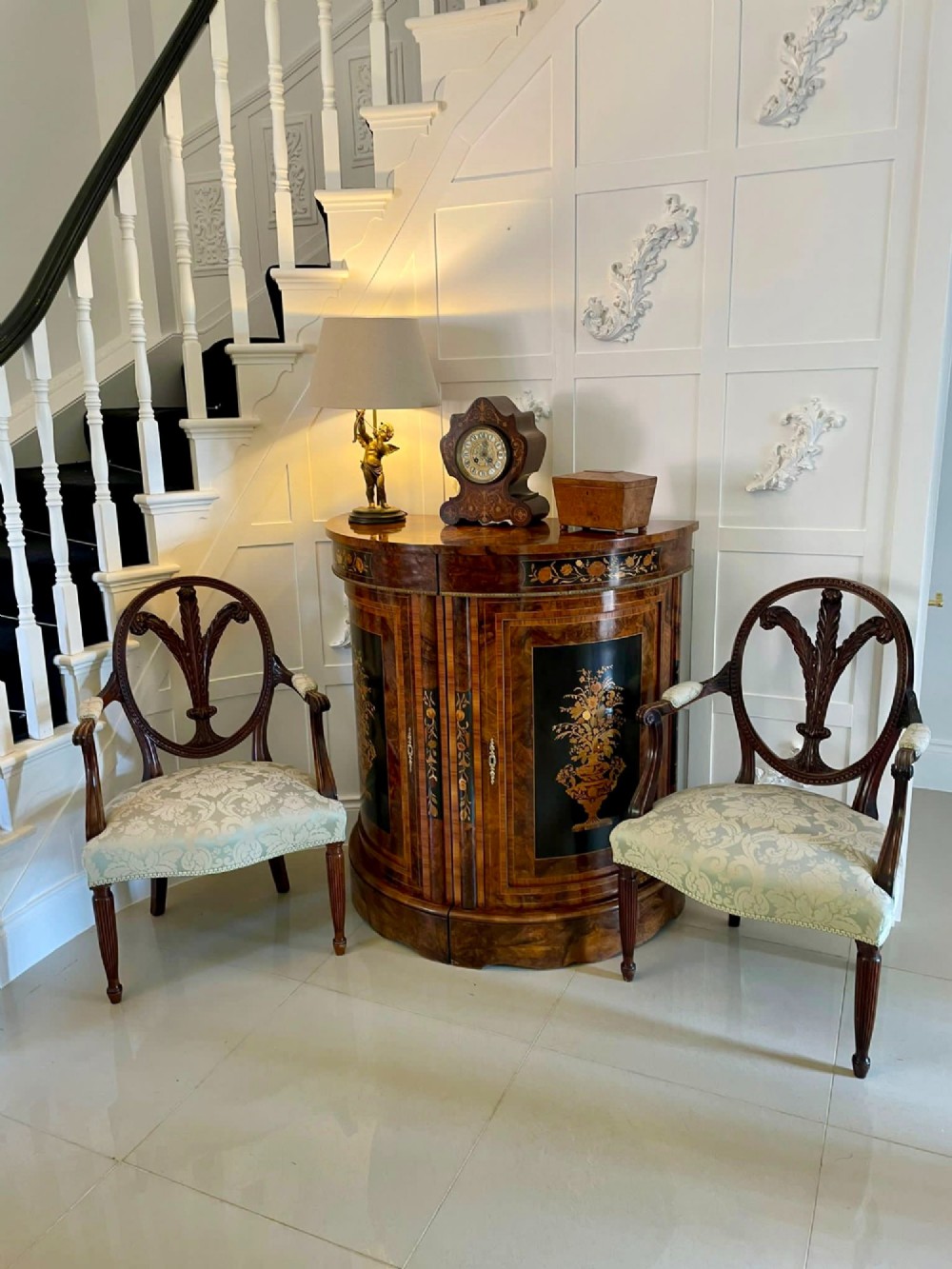 A pair of carved mahogany open armchairs featuring oval backs with carved splats, padded armrests, and pale green patterned fabric seats on fluted front legs. View XIV
