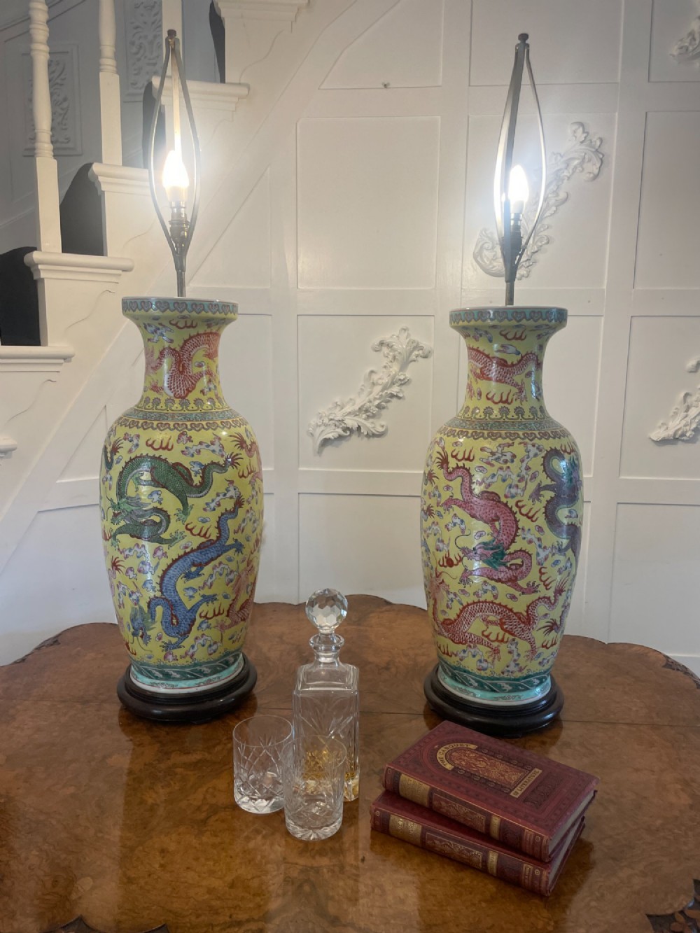 A pair of large 19th-century Chinese porcelain vase lamps featuring hand-painted dragons on a yellow ground, set on dark wooden bases. View II