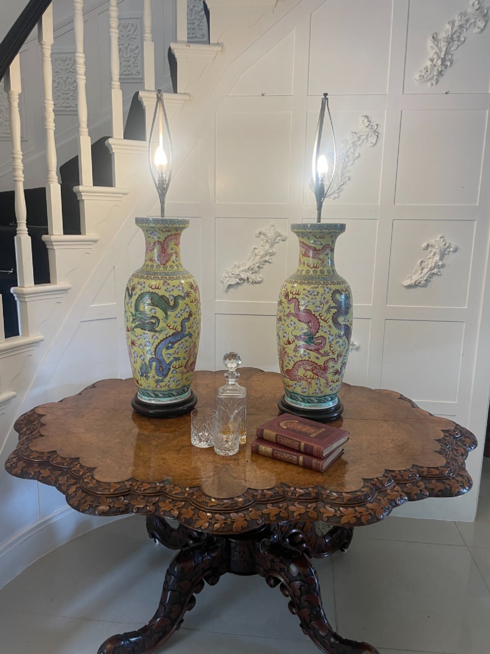 A pair of large 19th-century Chinese porcelain vase lamps featuring hand-painted dragons on a yellow ground, set on dark wooden bases. View III