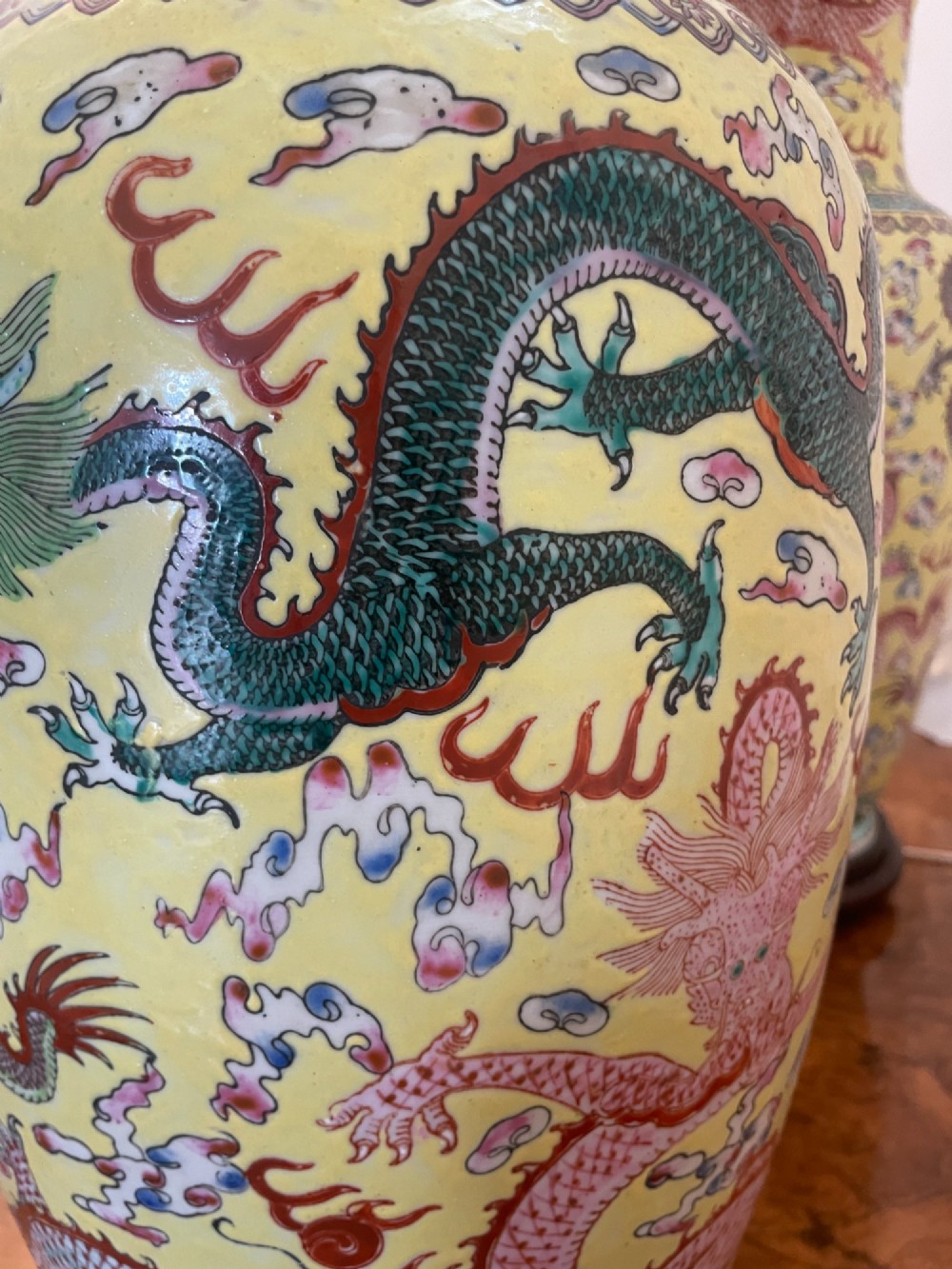 A pair of large 19th-century Chinese porcelain vase lamps featuring hand-painted dragons on a yellow ground, set on dark wooden bases. View VI