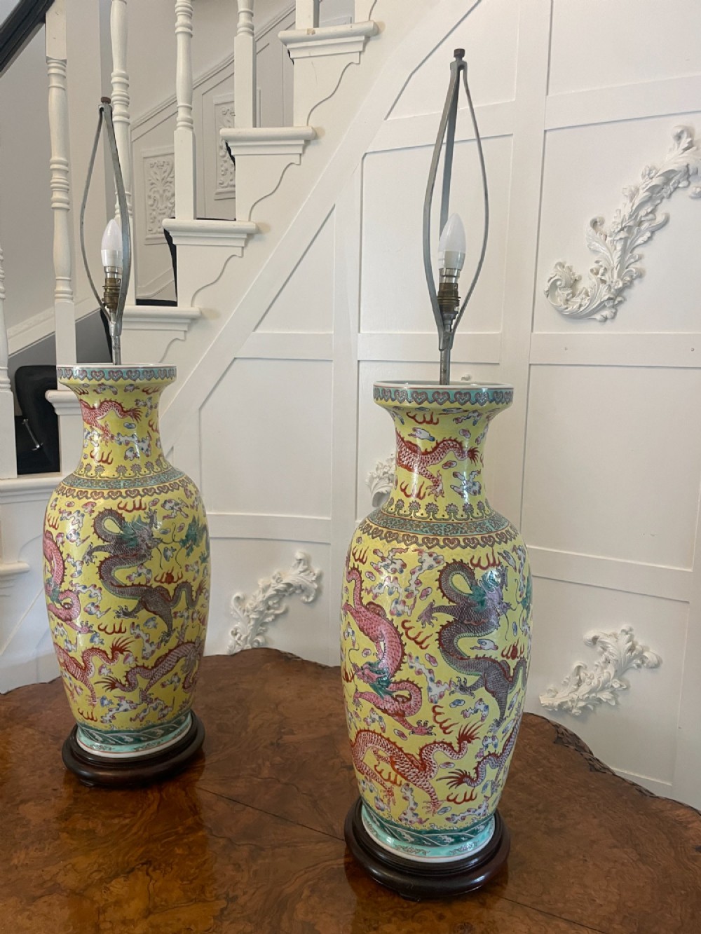 A pair of large 19th-century Chinese porcelain vase lamps featuring hand-painted dragons on a yellow ground, set on dark wooden bases. View XV