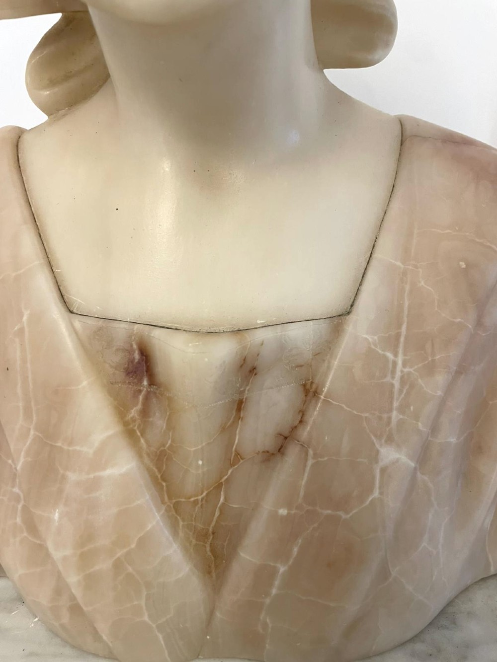 Carved Victorian alabaster bust depicting a young woman wearing a traditional bonnet, mounted on an octagonal marble base. View X