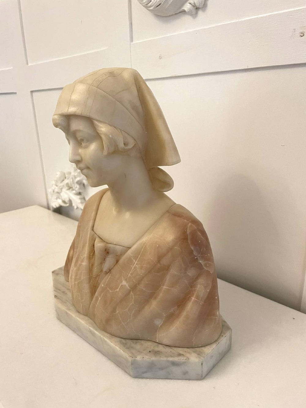 Carved Victorian alabaster bust depicting a young woman wearing a traditional bonnet, mounted on an octagonal marble base. View XIII