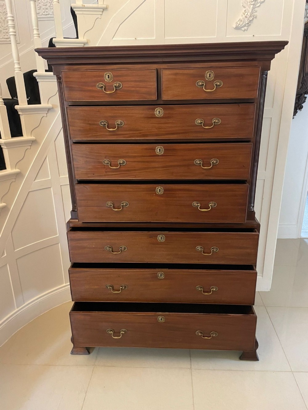 A tall George III mahogany chest on chest featuring two short over six long drawers with brass swan-neck handles and ogee bracket feet. View VIII