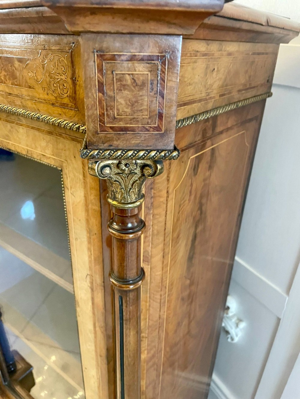 An antique Victorian burr walnut credenza featuring a central inlaid marquetry door flanked by two glazed display cabinets with brass mounts. View XII