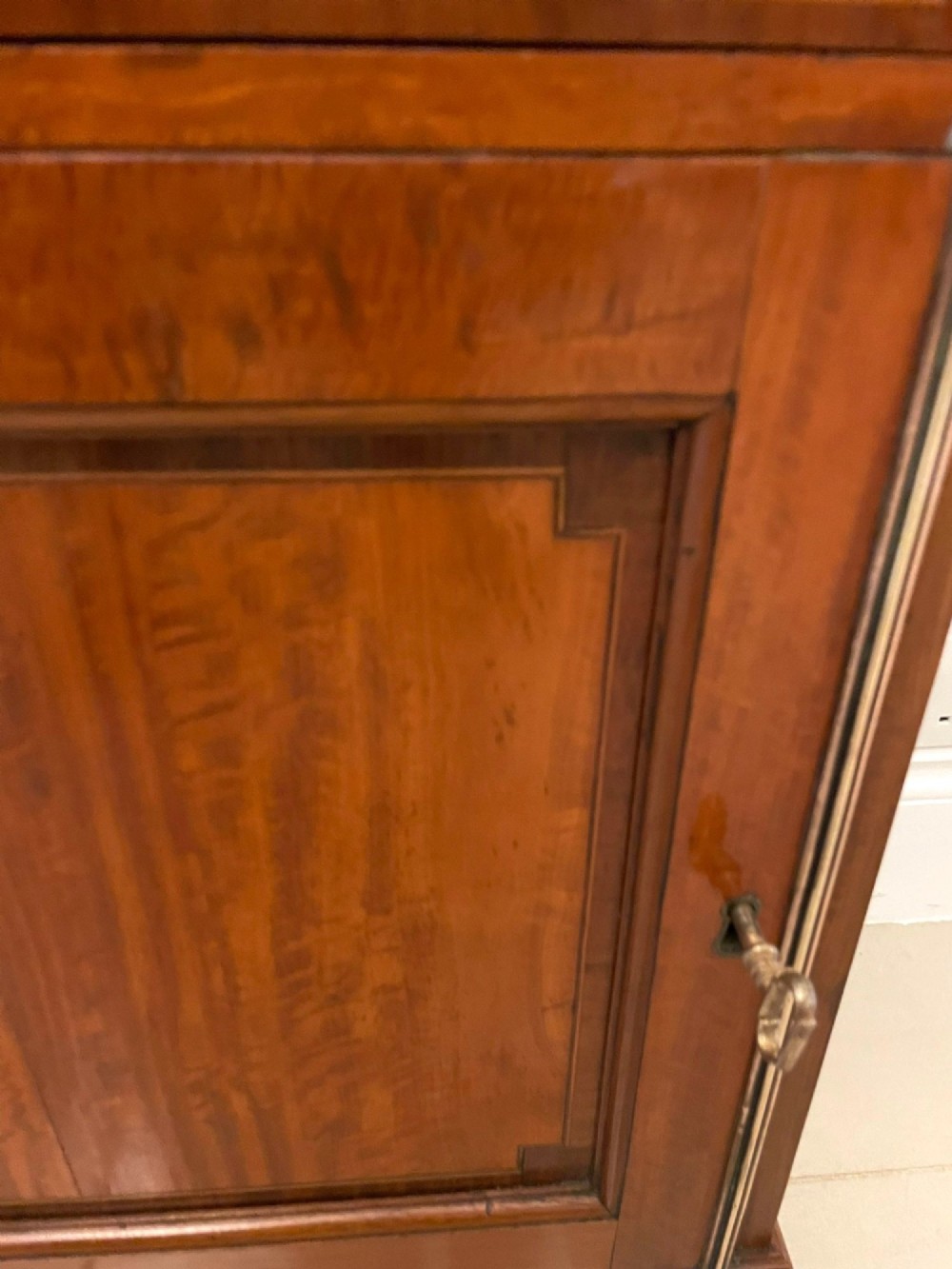 A pair of tall satinwood waterfall bookcases featuring tiered open shelves with brass gallery rails, single drawers, and lower panelled cupboards. View IX