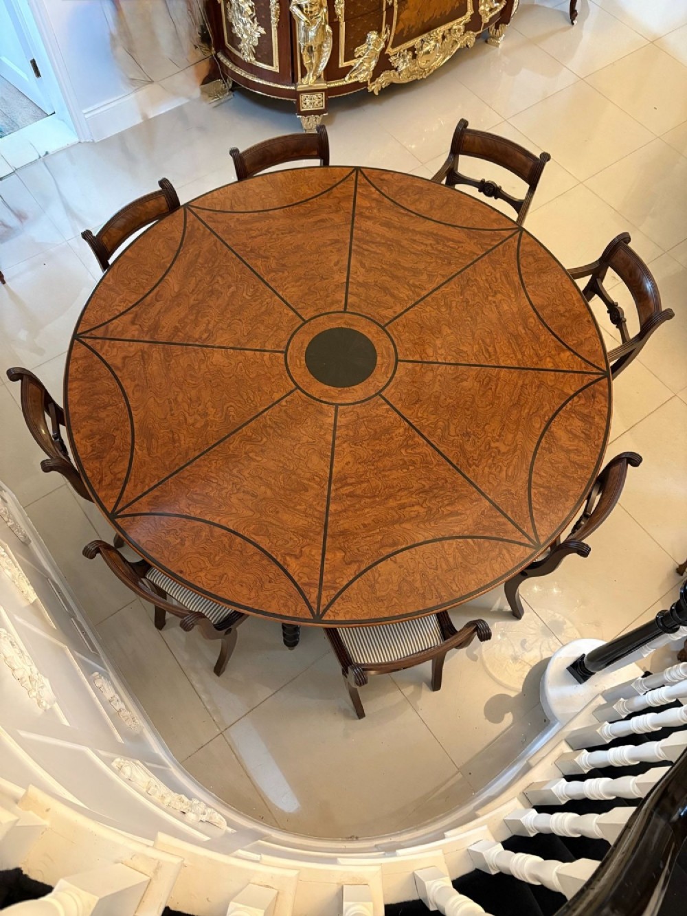 A large circular dining table crafted from burr pollard oak with geometric ebony inlay and ebonised bobbin legs. View IV
