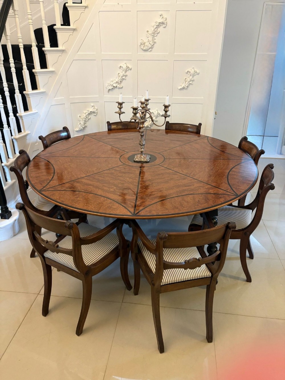 A large circular dining table crafted from burr pollard oak with geometric ebony inlay and ebonised bobbin legs. View V