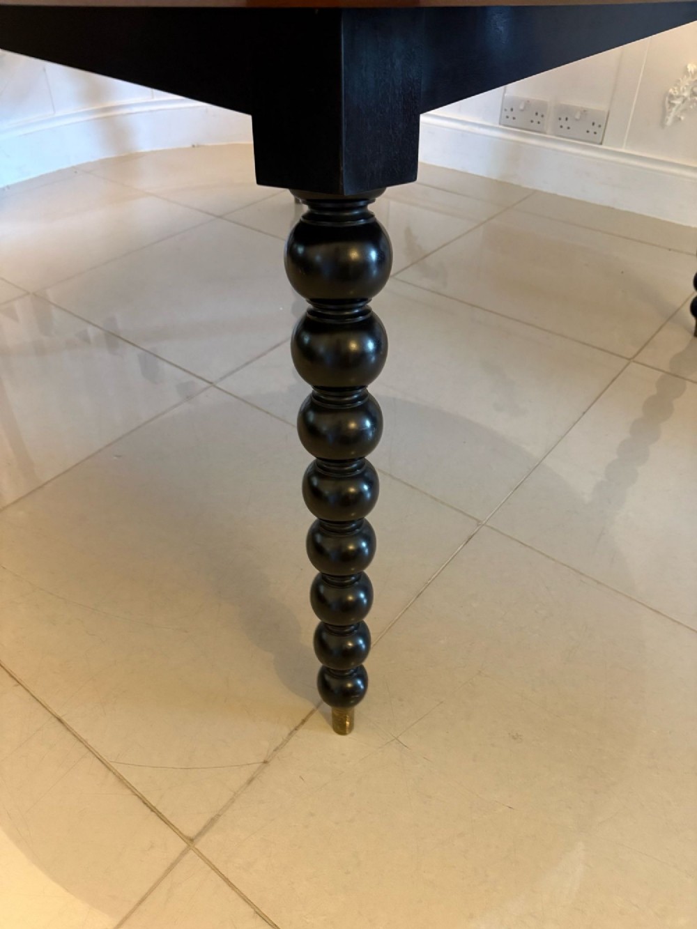 A large circular dining table crafted from burr pollard oak with geometric ebony inlay and ebonised bobbin legs. View VII