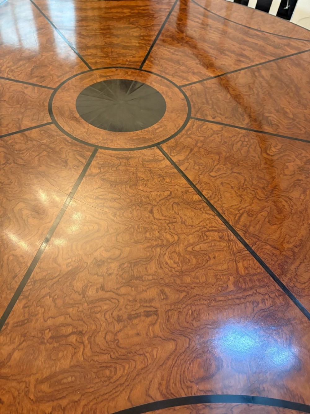 A large circular dining table crafted from burr pollard oak with geometric ebony inlay and ebonised bobbin legs. View IX