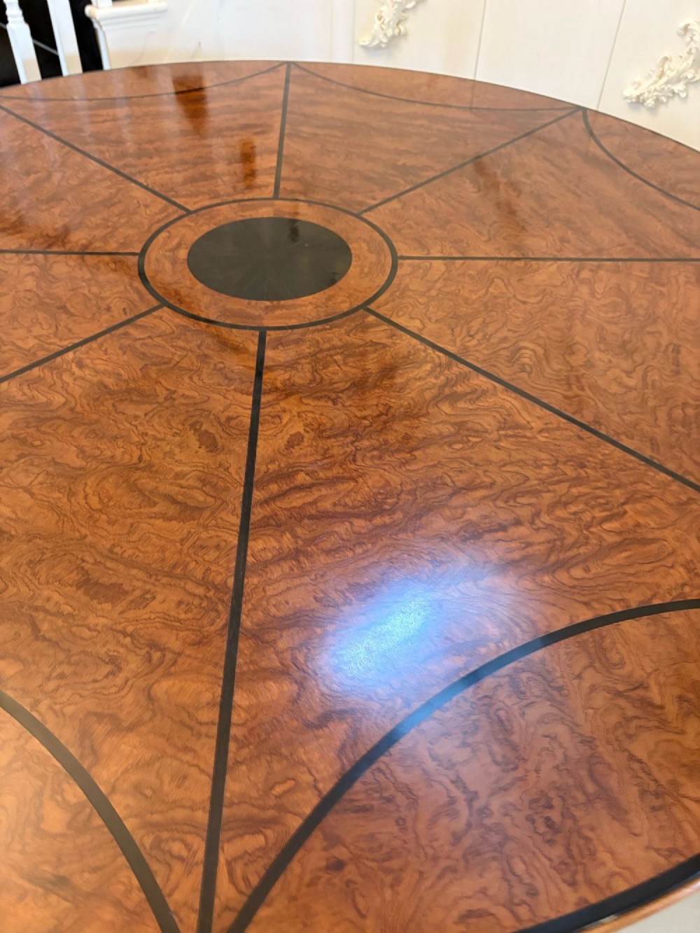 A large circular dining table crafted from burr pollard oak with geometric ebony inlay and ebonised bobbin legs. View X