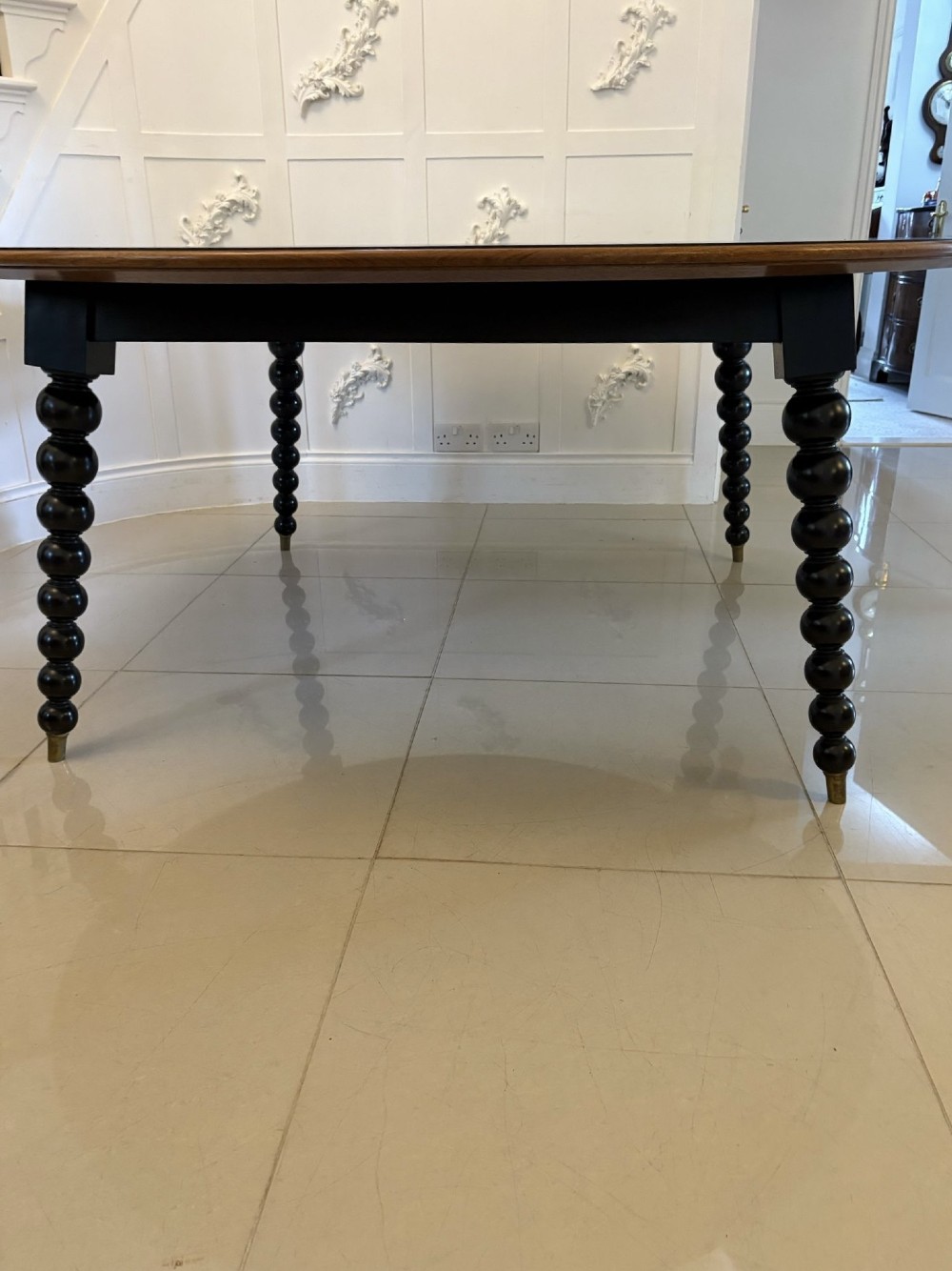 A large circular dining table crafted from burr pollard oak with geometric ebony inlay and ebonised bobbin legs. View XI