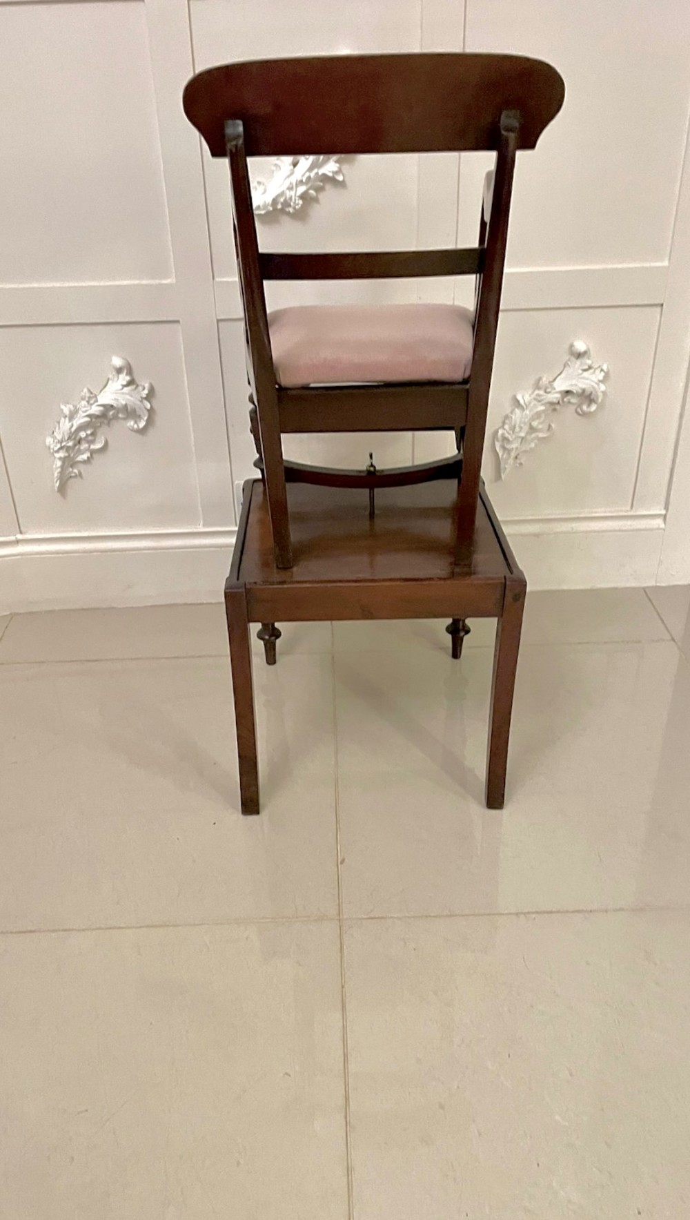 A William IV mahogany childs armchair with scroll arms and a pink upholstered seat, resting on a matching wooden conversion stand. View V