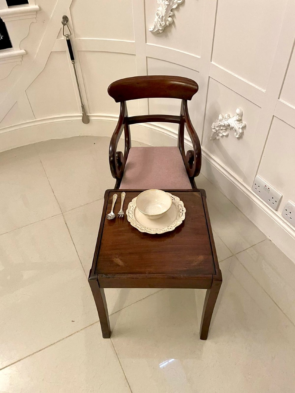 A William IV mahogany childs armchair with scroll arms and a pink upholstered seat, resting on a matching wooden conversion stand. View X