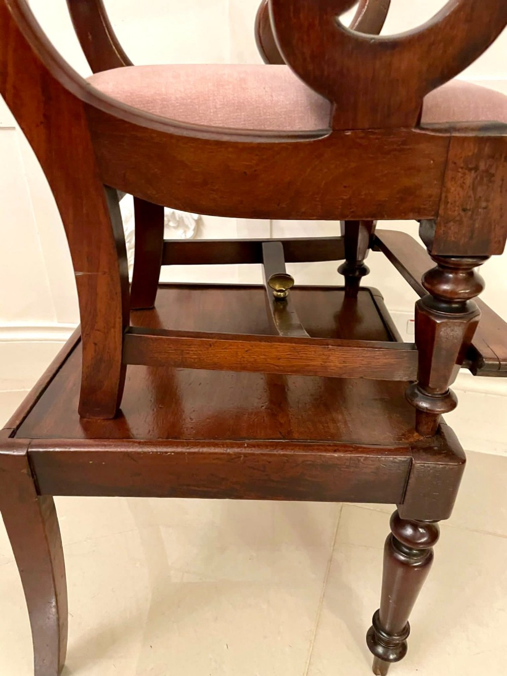 A William IV mahogany childs armchair with scroll arms and a pink upholstered seat, resting on a matching wooden conversion stand. View XV