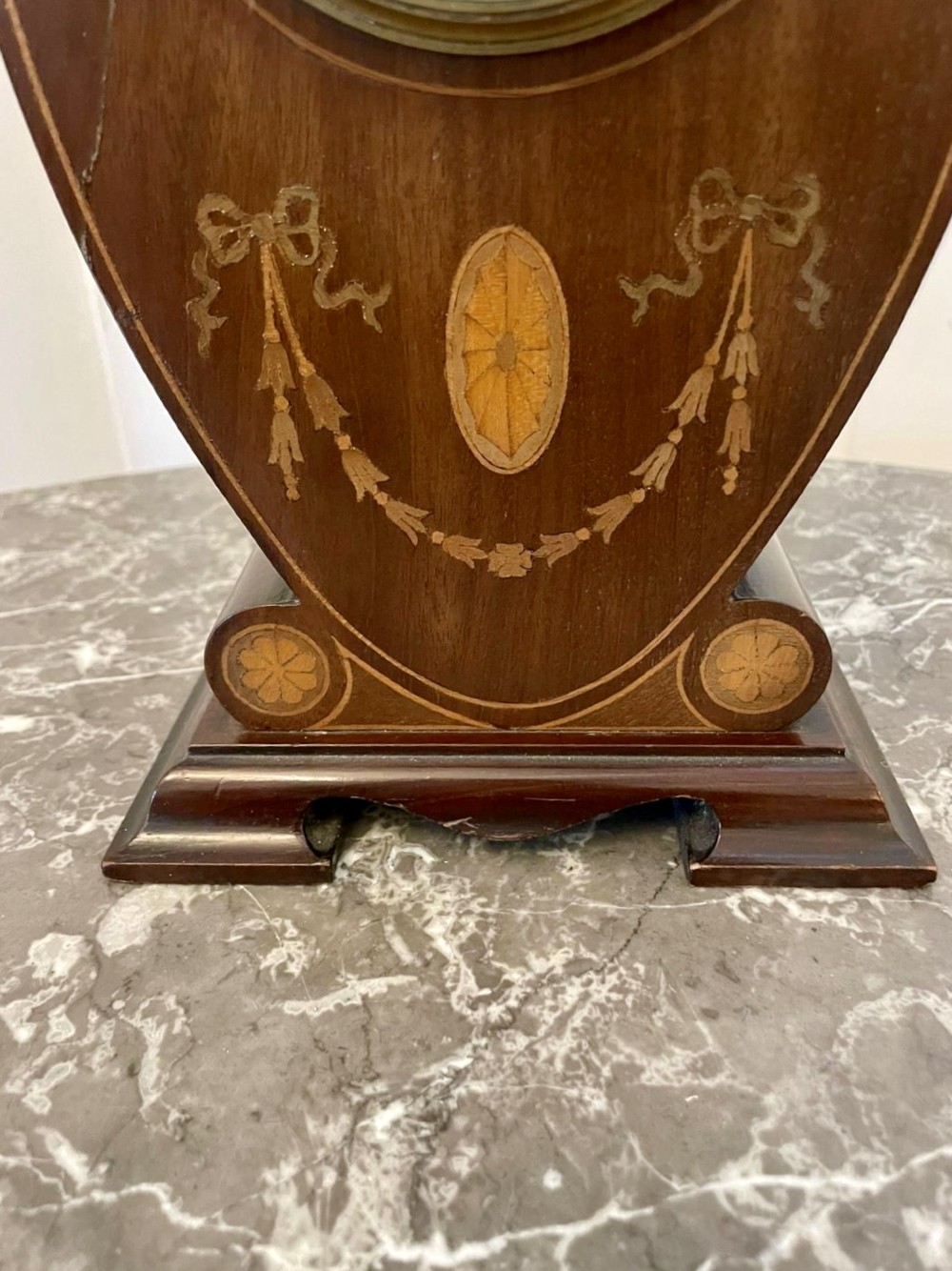 An Edwardian inlaid mahogany balloon-shaped mantel clock featuring decorative swags, floral paterae, and an enamel dial. View V