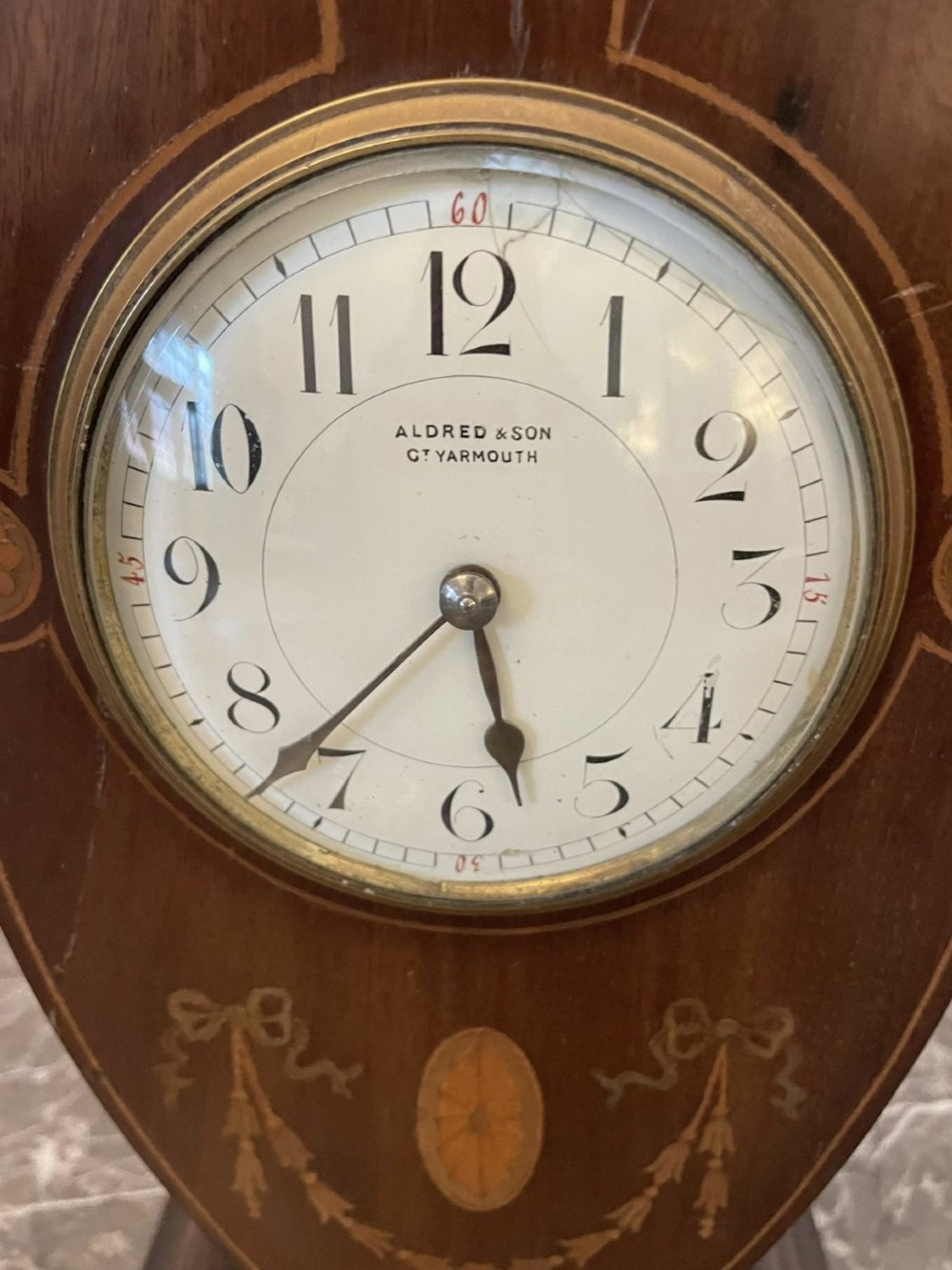 An Edwardian inlaid mahogany balloon-shaped mantel clock featuring decorative swags, floral paterae, and an enamel dial. View VII