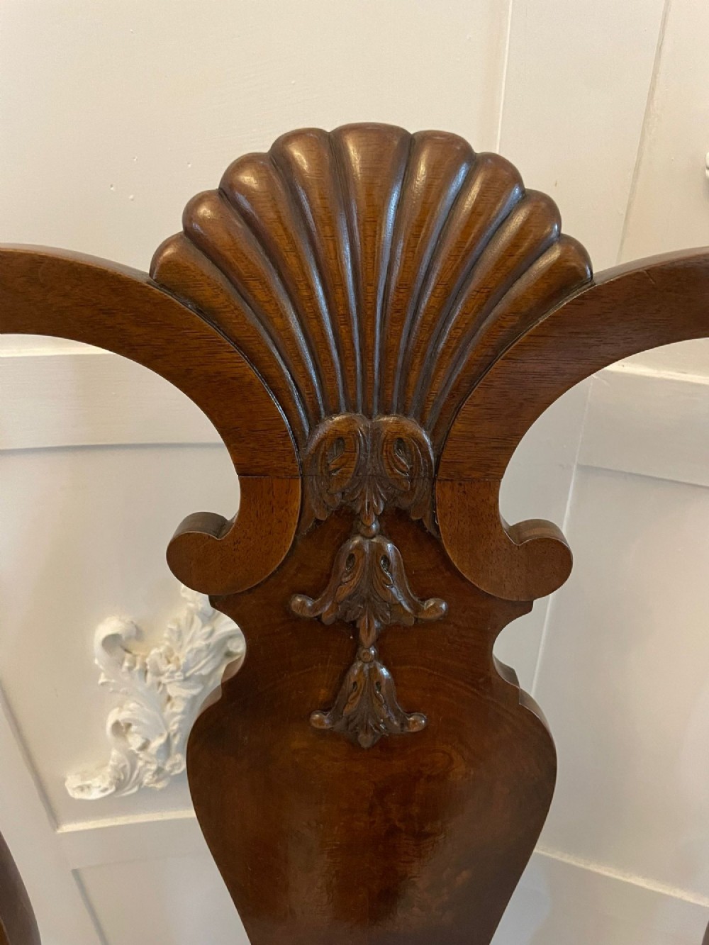 A set of ten walnut dining chairs featuring carved shell crests, splat backs, cabriole legs, and striped upholstered seats. View III