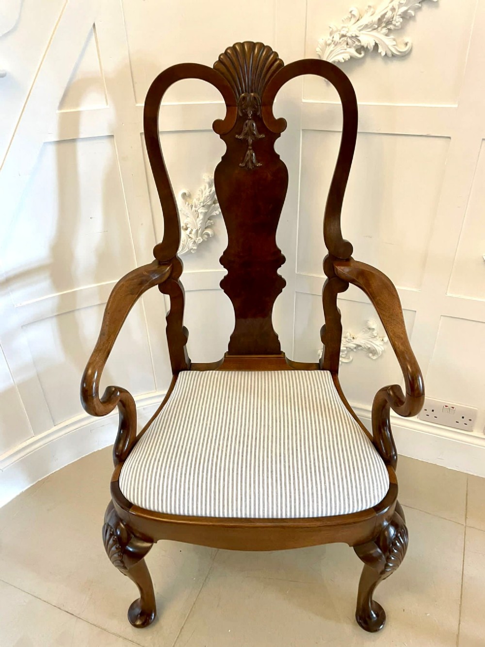 A set of ten walnut dining chairs featuring carved shell crests, splat backs, cabriole legs, and striped upholstered seats. View VI