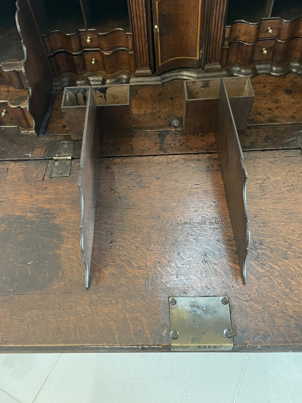 A 17th-century oak writing bureau featuring a slant-front lid above multiple drawers with brass teardrop handles and bracket feet. View III