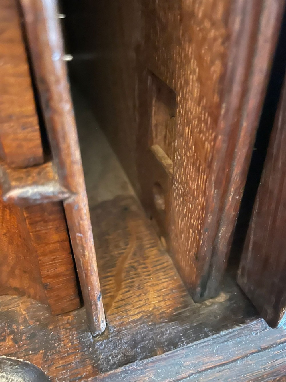 A 17th-century oak writing bureau featuring a slant-front lid above multiple drawers with brass teardrop handles and bracket feet. View XI