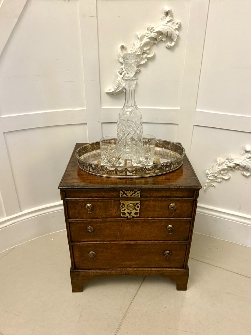 An early 18th-century dark oak box coffer styled as a miniature chest of drawers with decorative brass escutcheons, ring handles, and bracket feet. View III