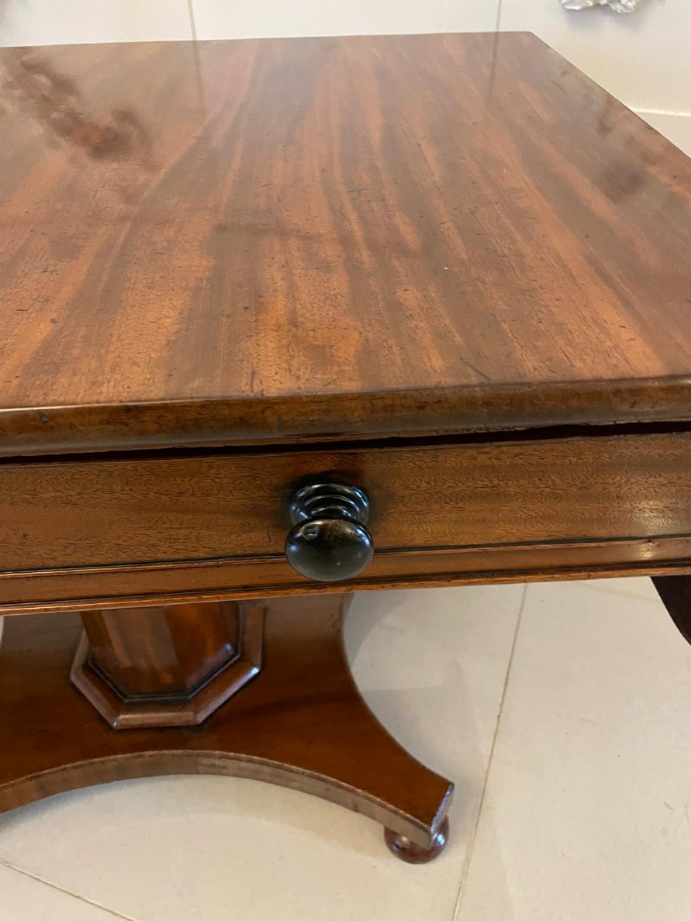 A Regency mahogany sofa table featuring two short drawers with black turned knobs, twin drop-leaf flaps, a central octagonal pedestal, and a quadruped base. View IV