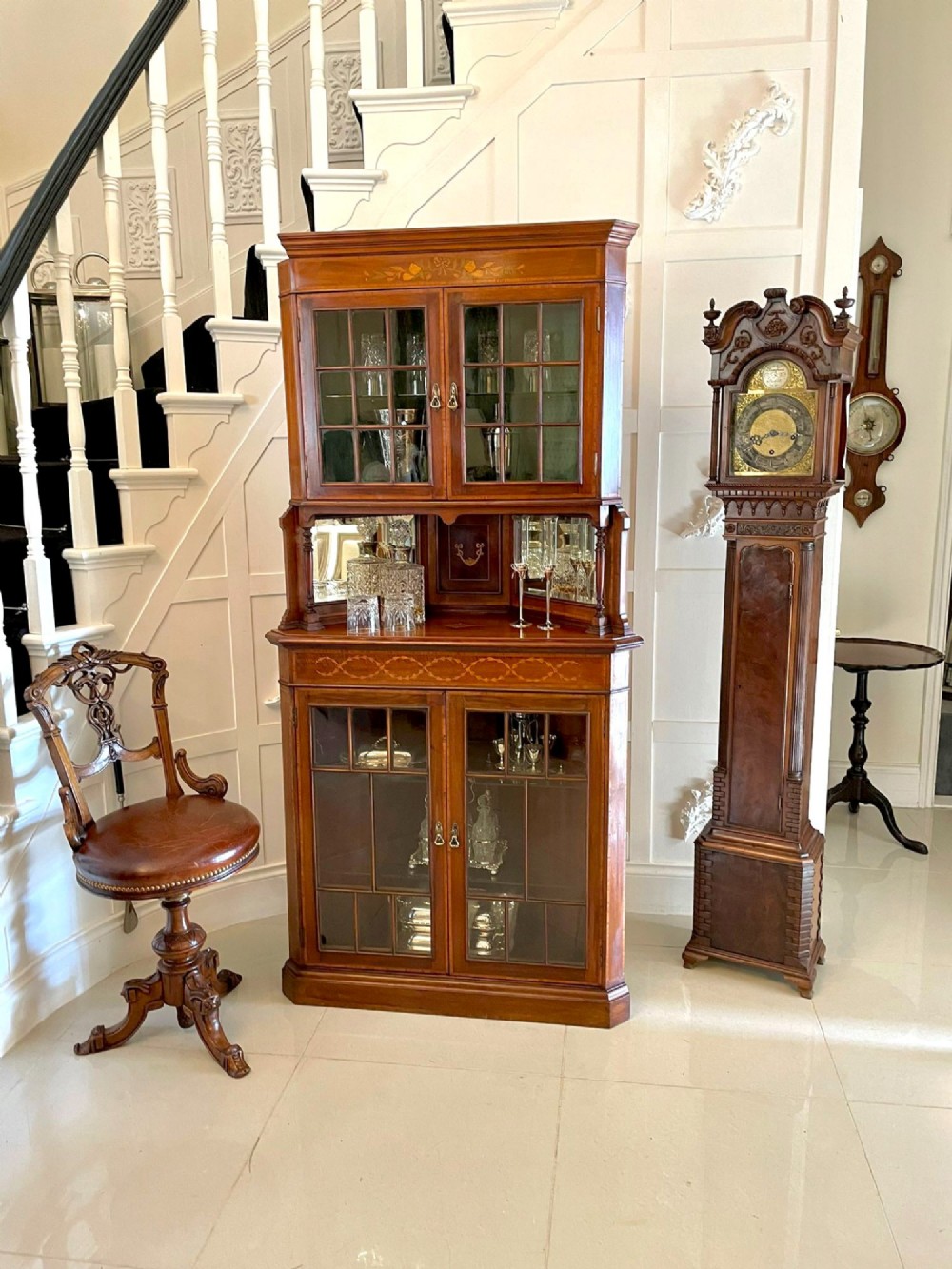 An Edwardian mahogany corner display cabinet featuring floral satinwood inlay, glazed doors with astragal bars, and a mirrored central niche. View III
