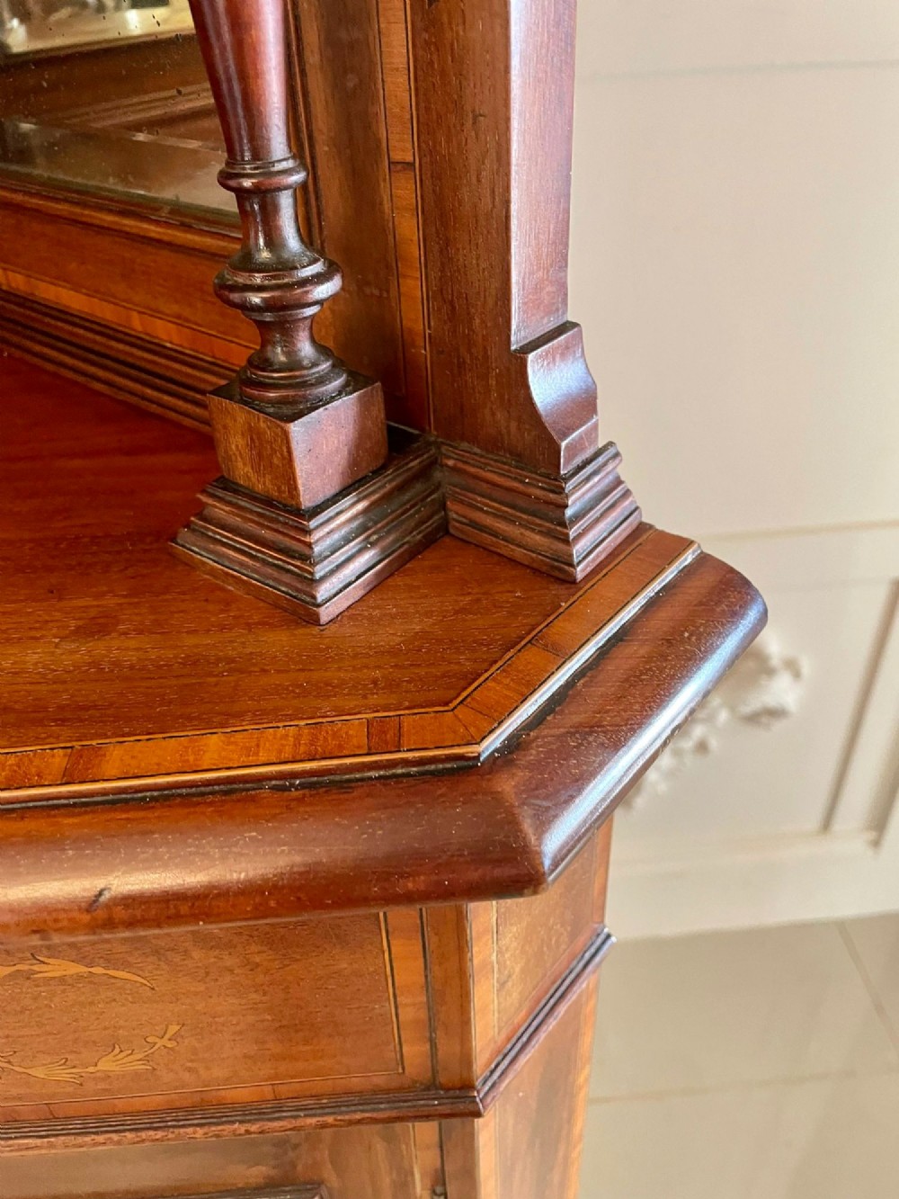 An Edwardian mahogany corner display cabinet featuring floral satinwood inlay, glazed doors with astragal bars, and a mirrored central niche. View X