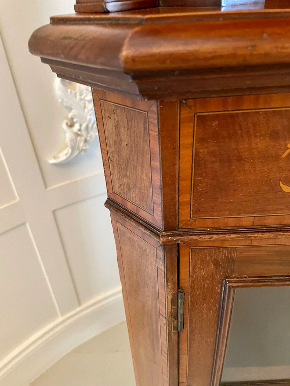 An Edwardian mahogany corner display cabinet featuring floral satinwood inlay, glazed doors with astragal bars, and a mirrored central niche. View XI