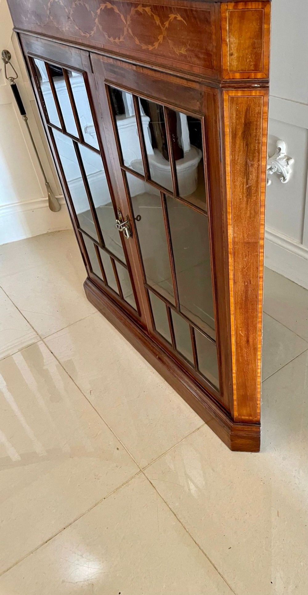 An Edwardian mahogany corner display cabinet featuring floral satinwood inlay, glazed doors with astragal bars, and a mirrored central niche. View XII