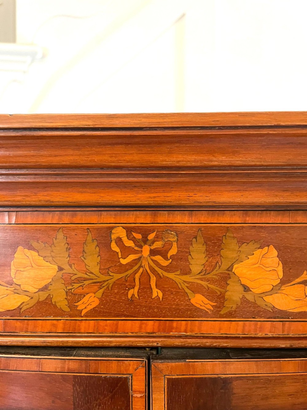 An Edwardian mahogany corner display cabinet featuring floral satinwood inlay, glazed doors with astragal bars, and a mirrored central niche. View XIII
