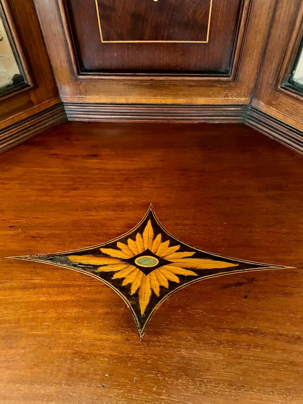 An Edwardian mahogany corner display cabinet featuring floral satinwood inlay, glazed doors with astragal bars, and a mirrored central niche. View XIV