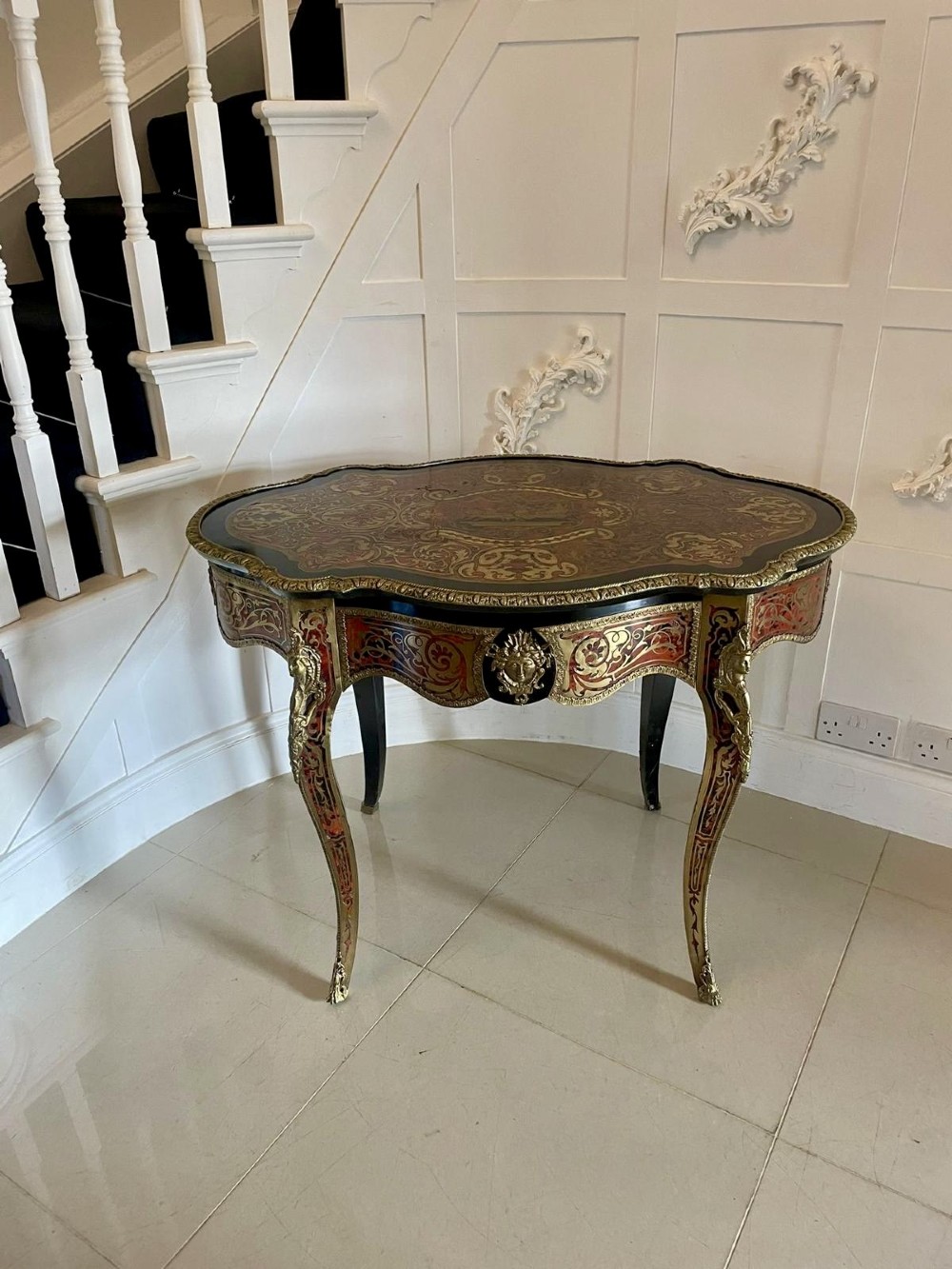 A French Boulle centre table featuring brass and tortoiseshell marquetry inlay, ebonised trim, gilt-bronze mounts, and cabriole legs. View XII