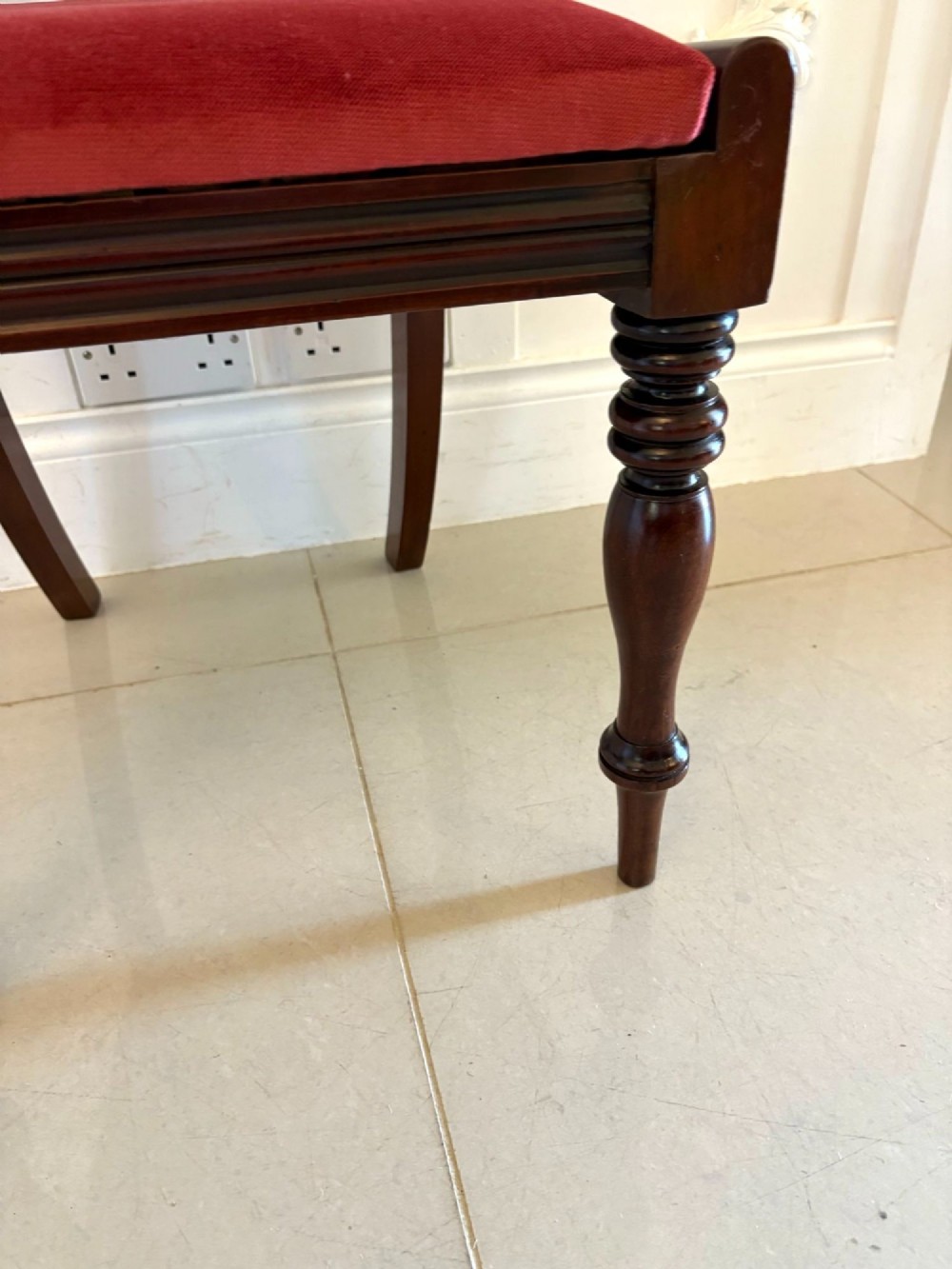 A set of eight Regency mahogany dining chairs featuring two carver armchairs and six side chairs with red upholstered seats. View V