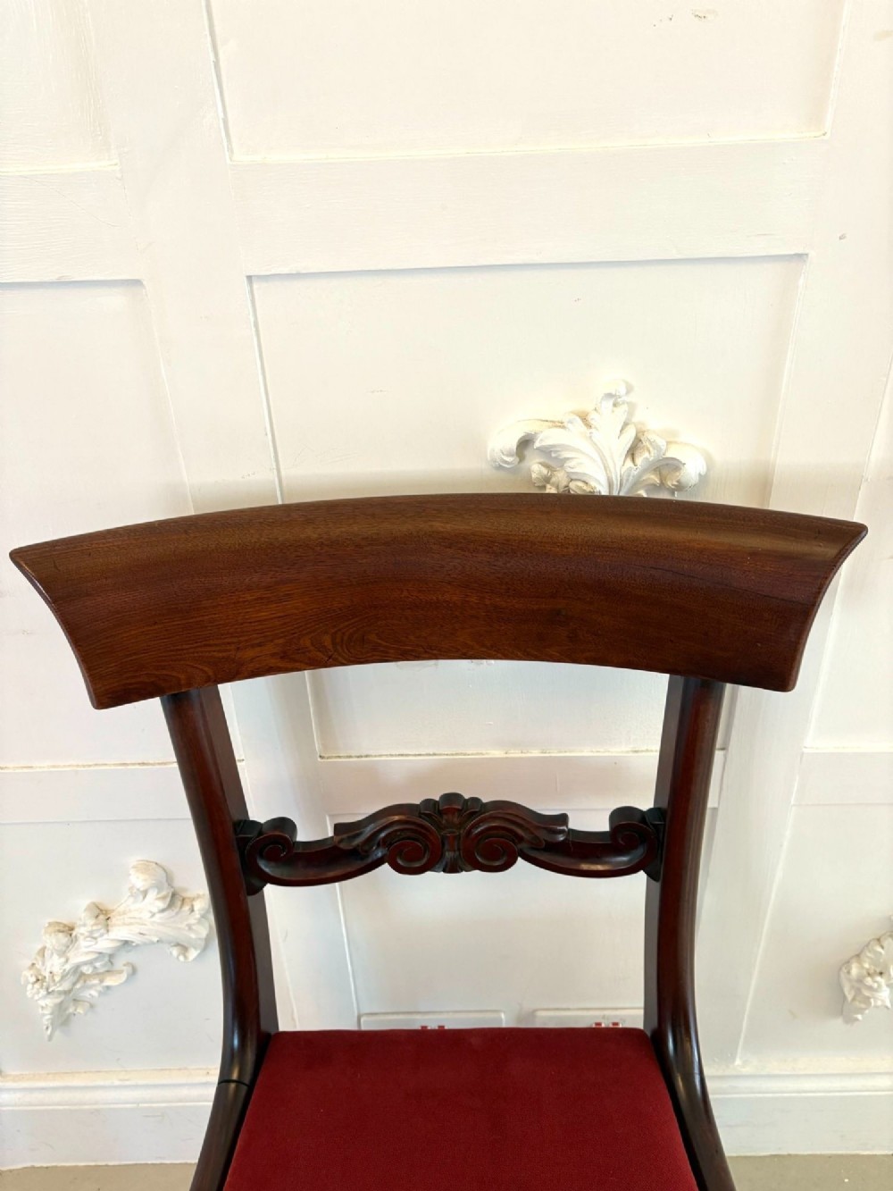 A set of eight Regency mahogany dining chairs featuring two carver armchairs and six side chairs with red upholstered seats. View VII