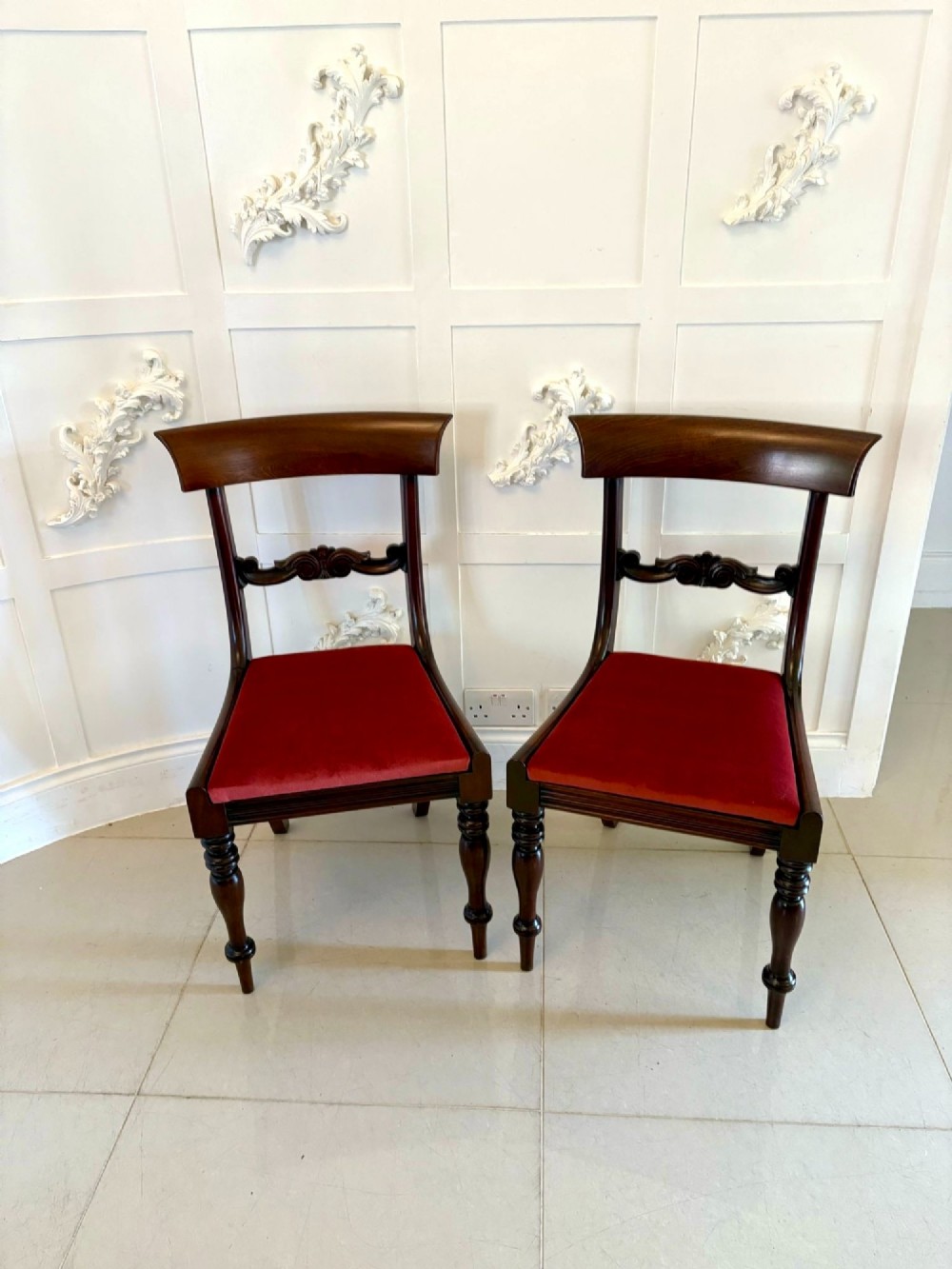 A set of eight Regency mahogany dining chairs featuring two carver armchairs and six side chairs with red upholstered seats. View X