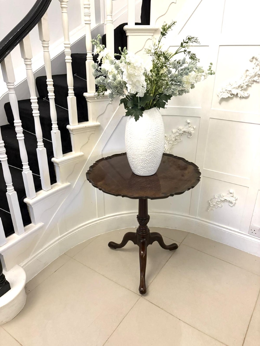 An 18th-century mahogany Chippendale tilt-top tripod table shown upright with a scalloped piecrust edge, turned column, and three cabriole legs. View II