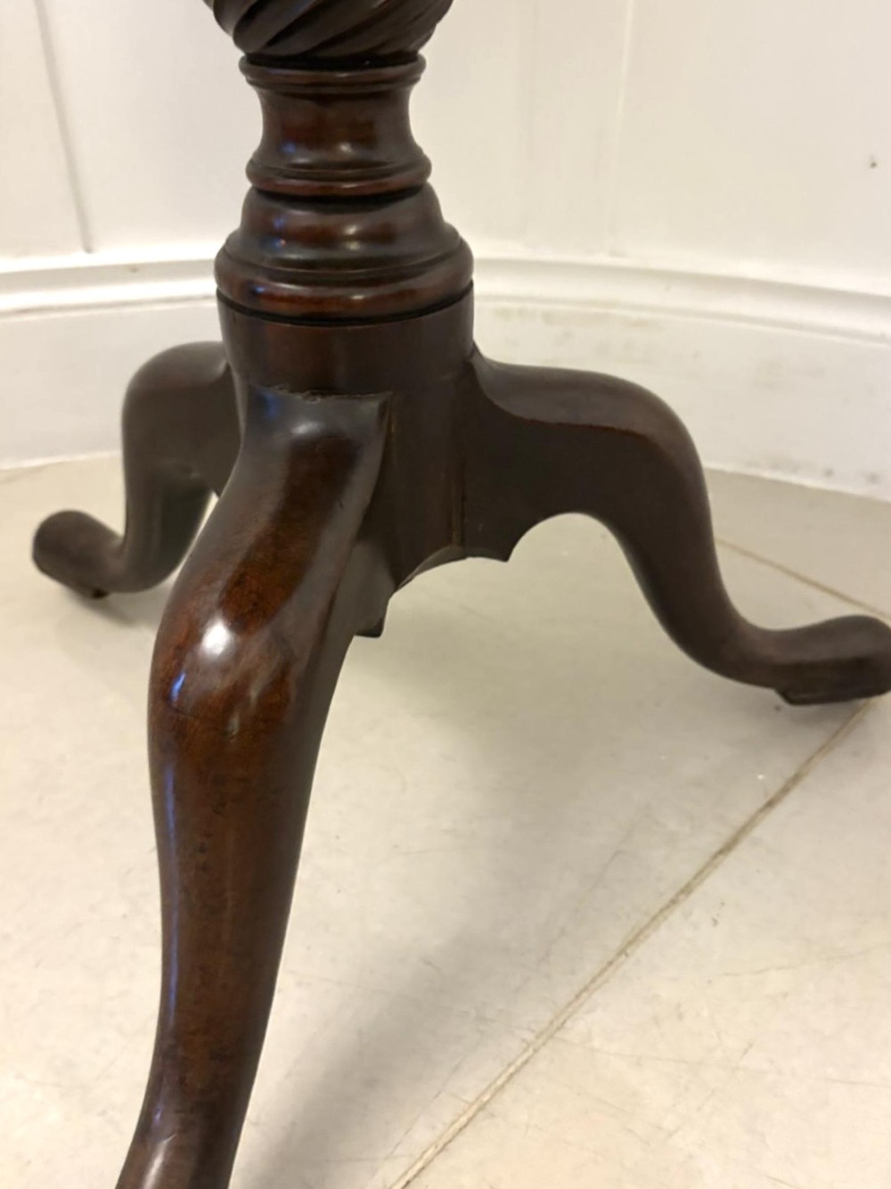 An 18th-century mahogany Chippendale tilt-top tripod table shown upright with a scalloped piecrust edge, turned column, and three cabriole legs. View III