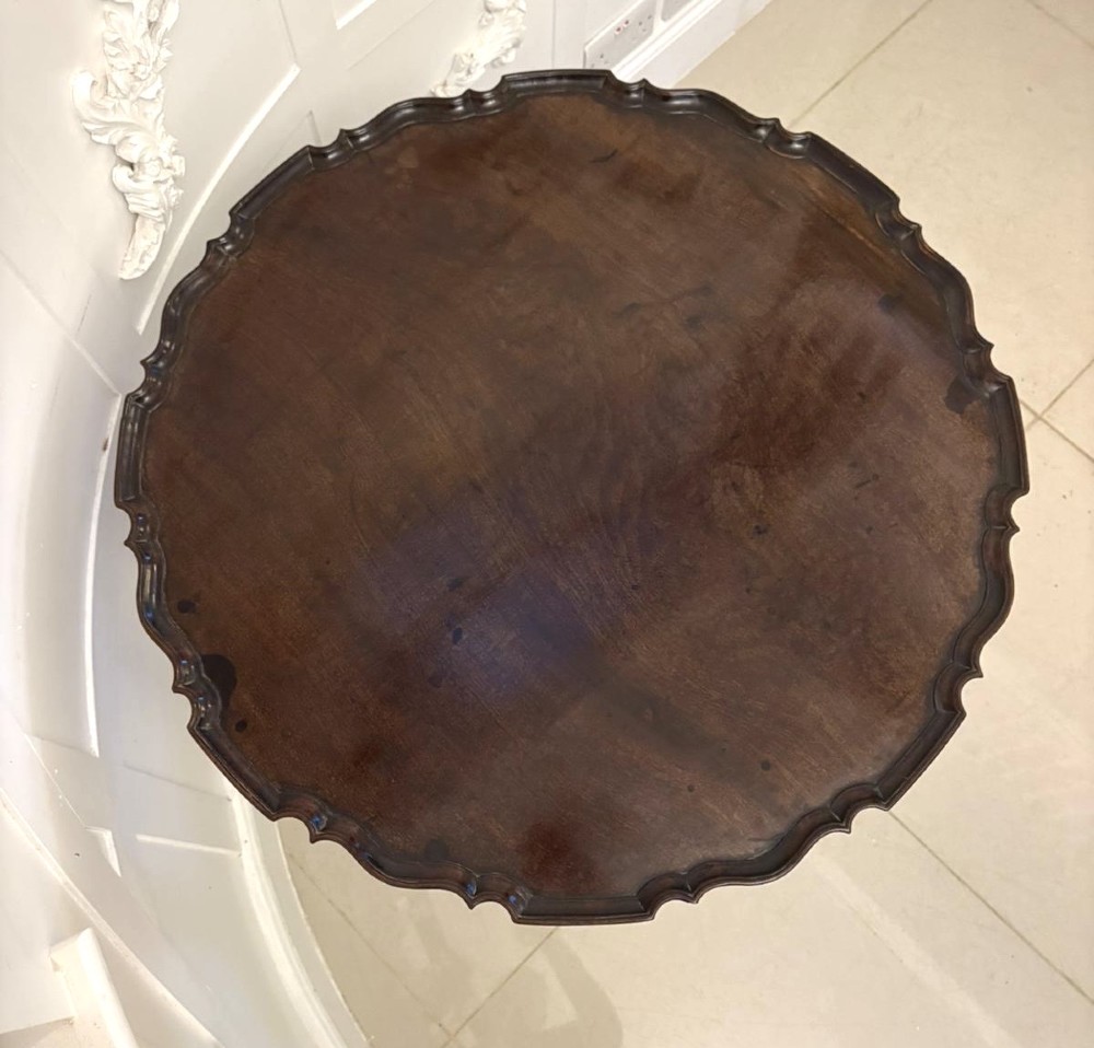 An 18th-century mahogany Chippendale tilt-top tripod table shown upright with a scalloped piecrust edge, turned column, and three cabriole legs. View IX