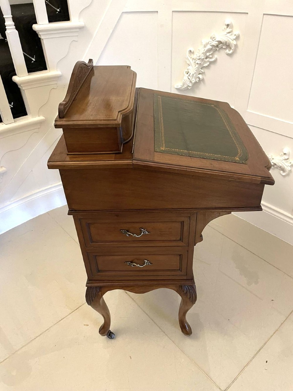 A Victorian walnut Davenport desk featuring a green leather writing slope, an upper stationery box, and carved cabriole legs on castors. View VII