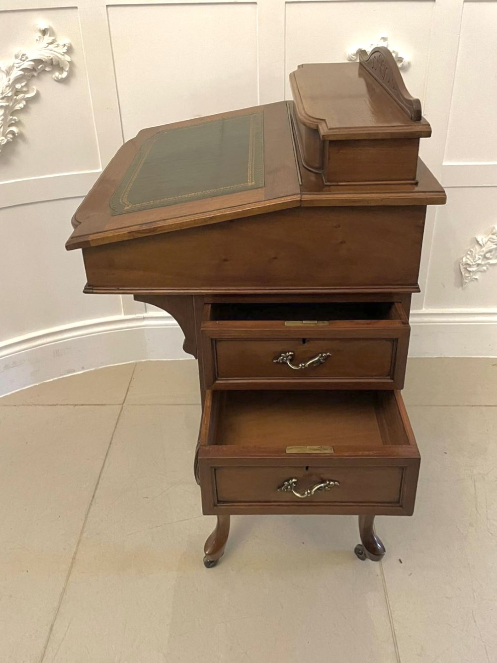A Victorian walnut Davenport desk featuring a green leather writing slope, an upper stationery box, and carved cabriole legs on castors. View IX