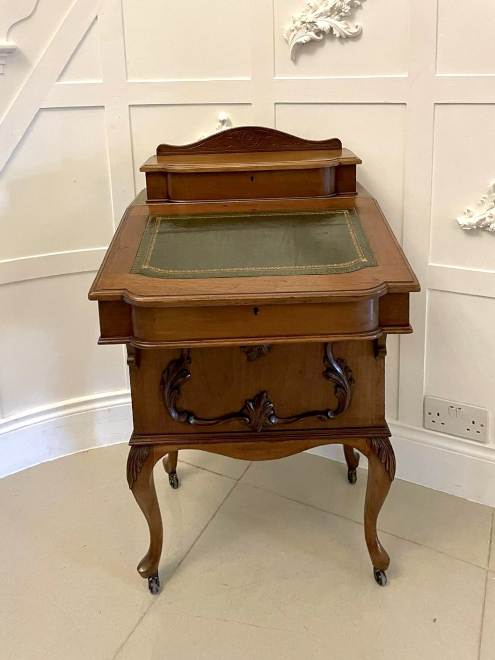 A Victorian walnut Davenport desk featuring a green leather writing slope, an upper stationery box, and carved cabriole legs on castors. View XII