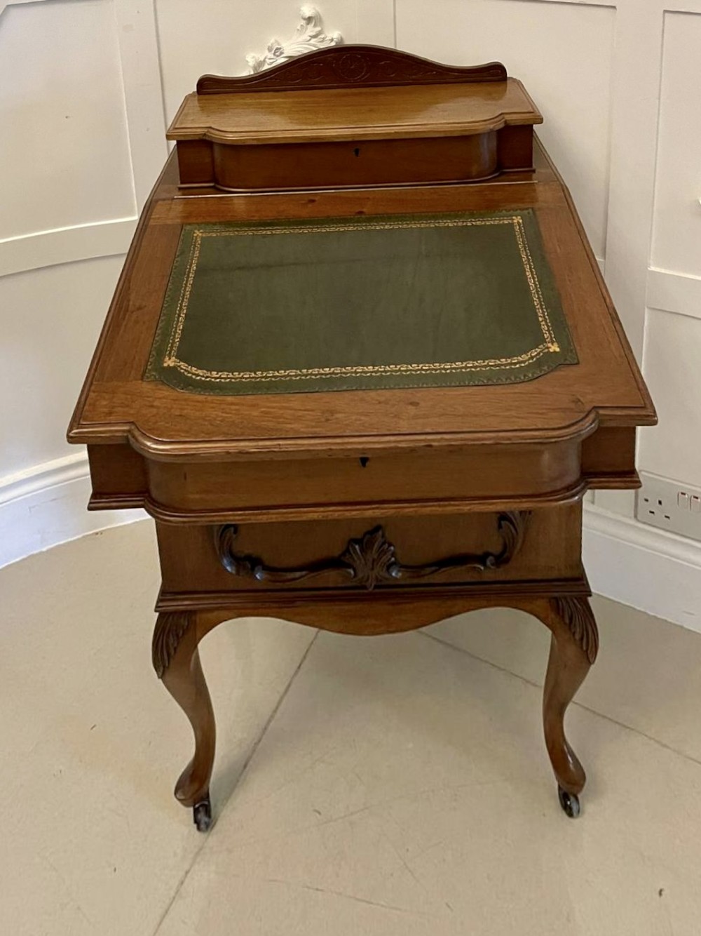 A Victorian walnut Davenport desk featuring a green leather writing slope, an upper stationery box, and carved cabriole legs on castors. View XIII