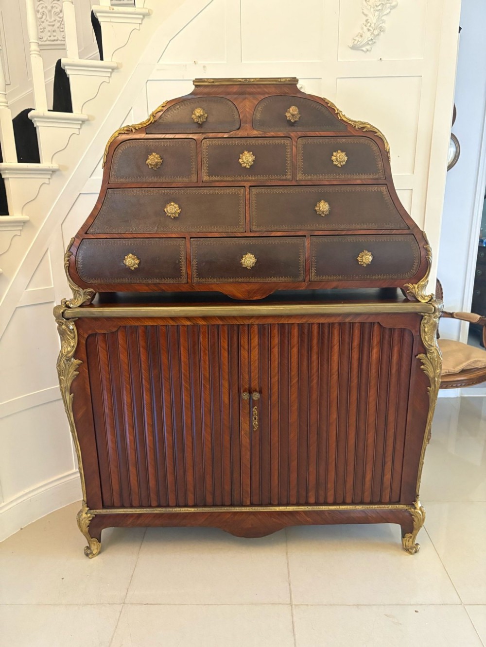 A nineteenth-century French kingwood cartonnier cabinet with leather-faced document drawers and gilded bronze mounts above a fluted cupboard base.