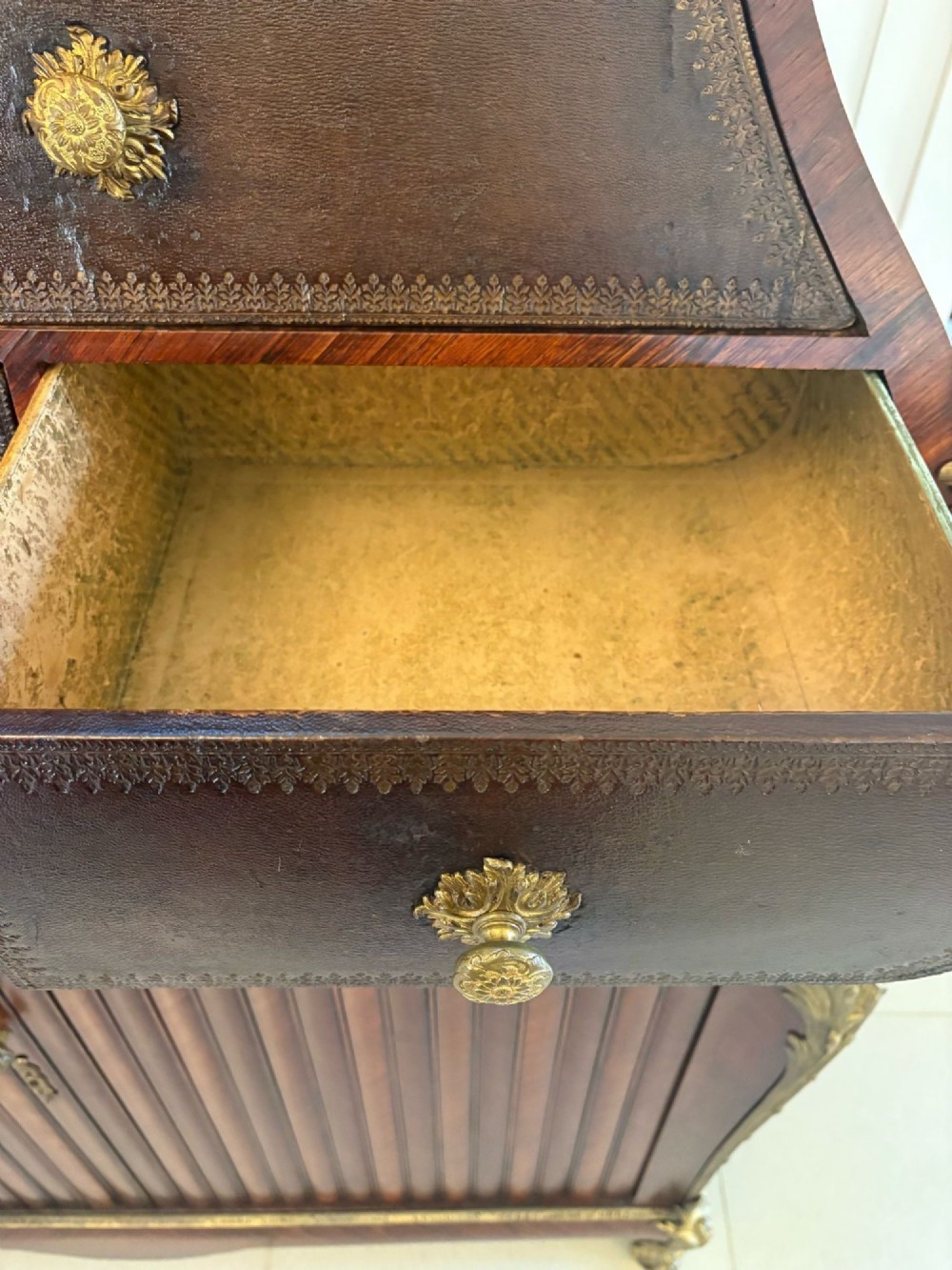A nineteenth-century French kingwood cartonnier cabinet with leather-faced document drawers and gilded bronze mounts above a fluted cupboard base. View V