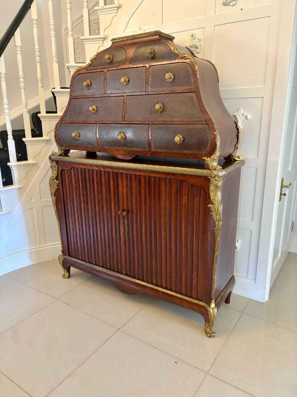 A nineteenth-century French kingwood cartonnier cabinet with leather-faced document drawers and gilded bronze mounts above a fluted cupboard base. View VII