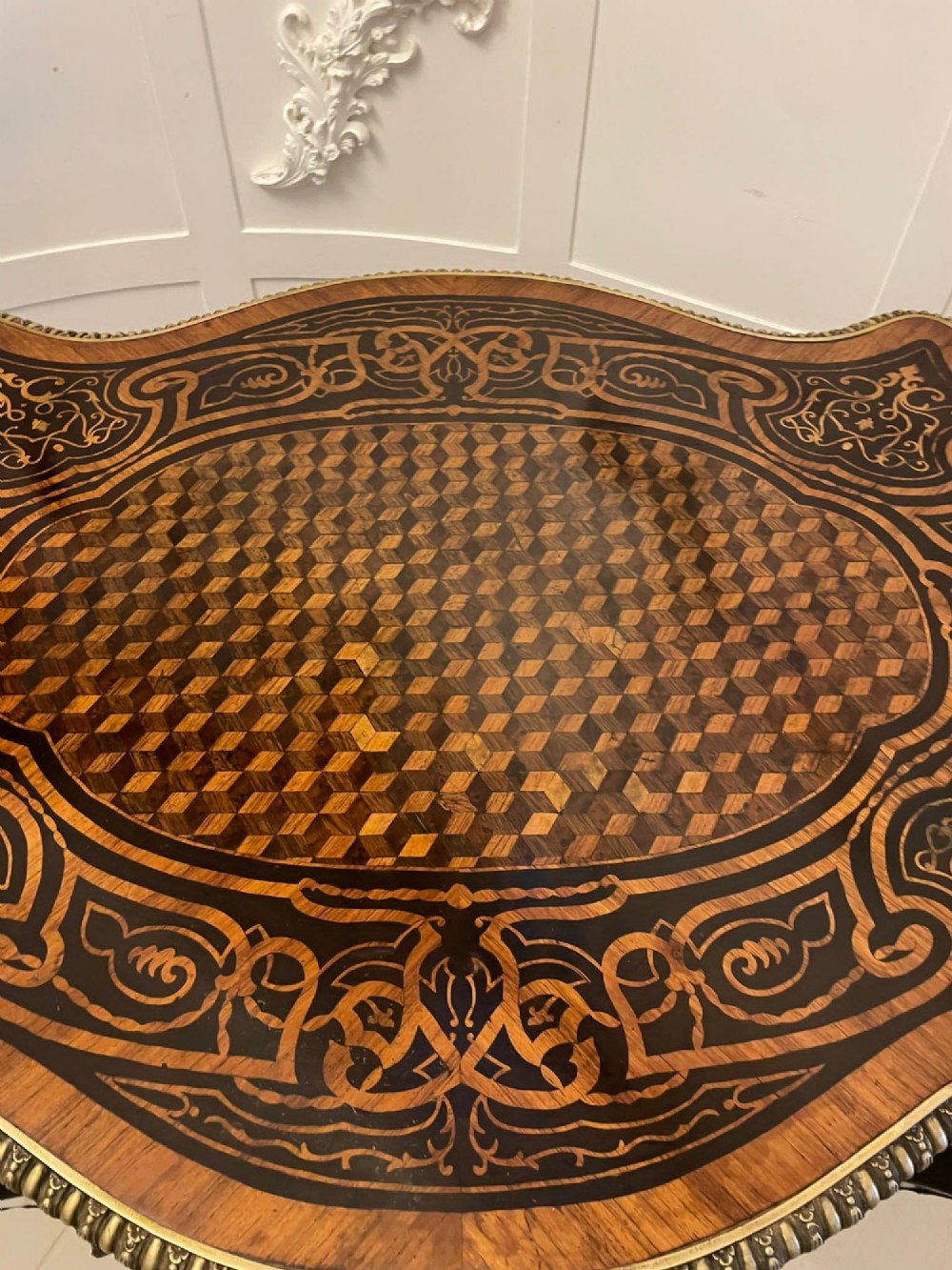 An antique French Rococo Revival centre table featuring detailed marquetry and parquetry wood patterns, serpentine edges, brass ormolu mounts, and curved cabriole legs. View III