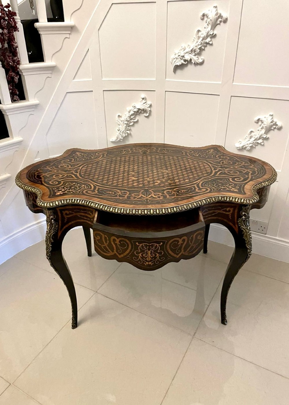 An antique French Rococo Revival centre table featuring detailed marquetry and parquetry wood patterns, serpentine edges, brass ormolu mounts, and curved cabriole legs. View XI